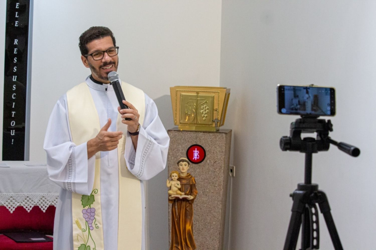 Pe Tiago Síbula transmitindo a missa pelas redes sociais na época da pandemia do COVID-19 em 2020