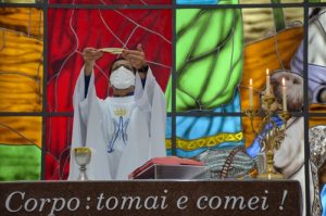 Padre Tiago Síbula consagrando no primeiro dia do tríduo da festa de Santa Rita de Cássia 2021