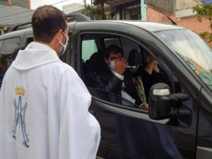 Padre Tiago Síbula abençoando um carro