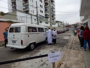 Padre Tiago Síbula abençoando um carro e seus passageiros