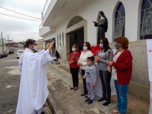 Padre Tiago Síbula abençoando pedestres que vieram trazer a sua doação