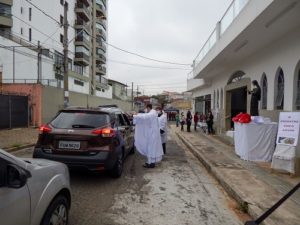 Padre Tiago Síbula abençoando um carro e seus  passageiros