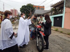 Padre Tiago abençoando um motoqueiro doador
